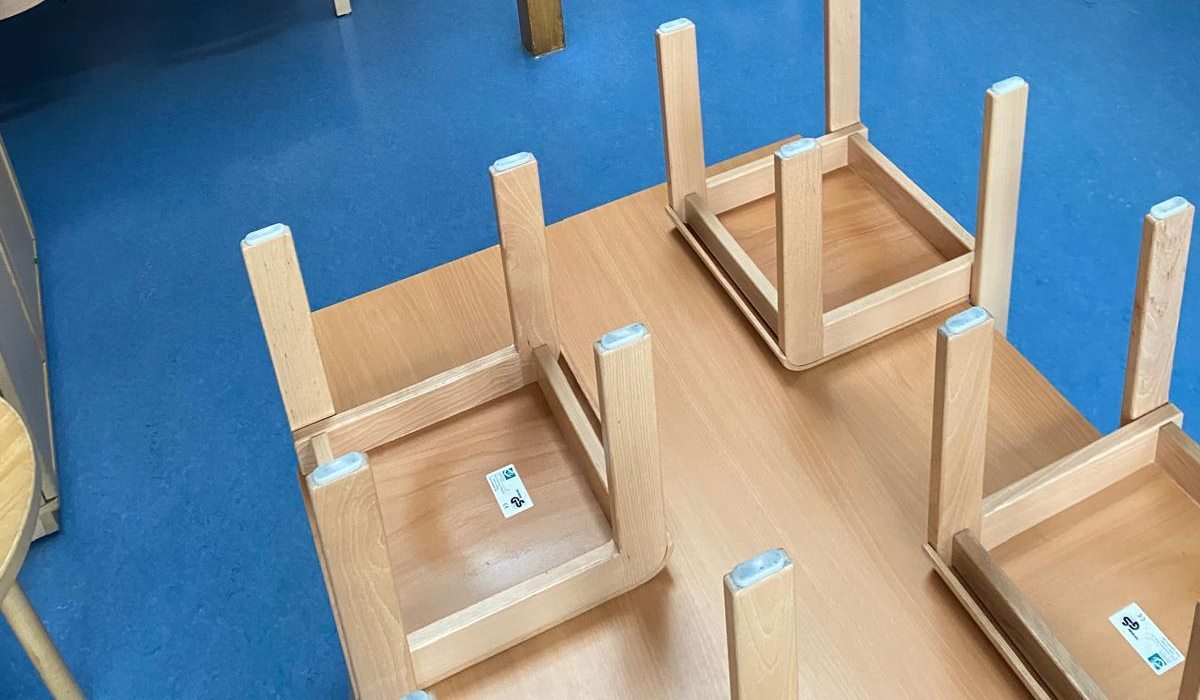 Boden eines Gruppenraums nach der Grundreinigung, Stühle hochgestellt